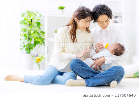 A couple giving milk to their baby 117504640