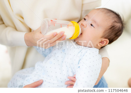A couple giving milk to their baby 117504646