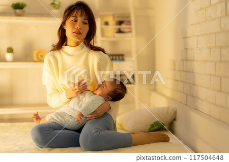 Tired woman giving milk in the middle of the night Tired woman giving milk in the middle of the night 117504648