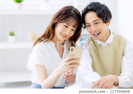 A couple looking at a smartphone A couple looking at a smartphone 117504668