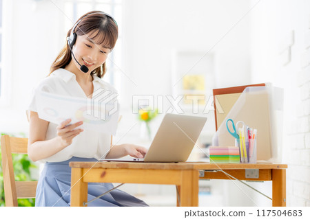 一名年輕女子在家工作時召開線上會議 117504683