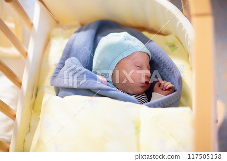 Newborn baby boy in hospital cot 117505158