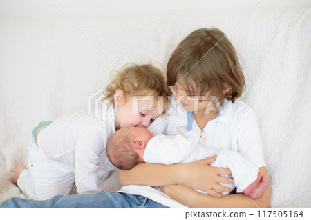 Siblings meet newborn baby in hospital 117505164