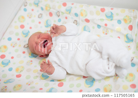 Newborn baby boy in hospital cot 117505165