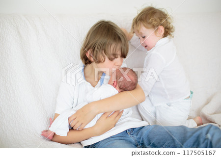 Siblings meet newborn baby in hospital 117505167