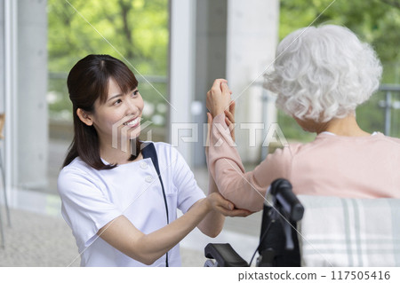 物理治療師為一名老年婦女進行復健治療 物理治療師為一名老年婦女進行復健治療 117505416