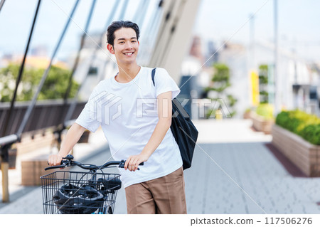 Young man commuting by bicycle Young man commuting by bicycle 117506276