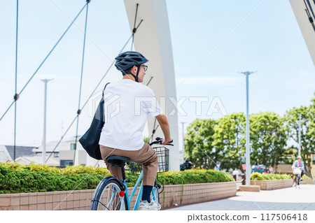 Young man commuting by bicycle Young man commuting by bicycle 117506418