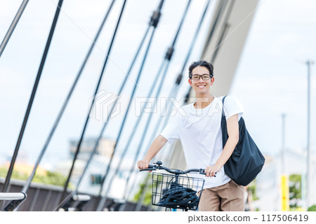 Young man commuting by bicycle 117506419