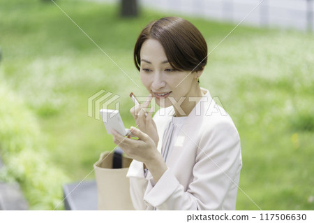 公園裡塗口紅的中年婦女 117506630