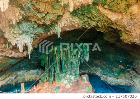 View of beautiful natural pool of crystal clear water formed in a rocky cave with stalagmites and stalagmites. Kuza cave in Zanzibar, Tanzania View of beautiful natural pool of crystal clear water formed in a rocky cave with stalagmites and stalagmites. Kuza cave in Zanzibar, Tanzania 117507020