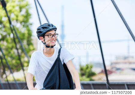 Young man commuting by bicycle 117507200
