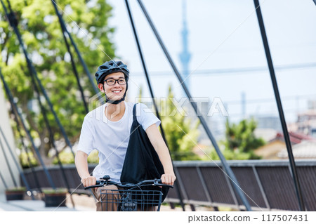 Young man commuting by bicycle 117507431
