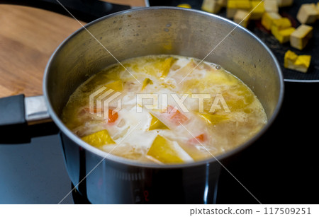 Chef at the kitchen preparing pumpkin porridge with tofu and vegetables Chef at the kitchen preparing pumpkin porridge with tofu and vegetables 117509251