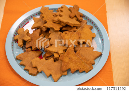 Plate with Christmas cookies on a table 117511292