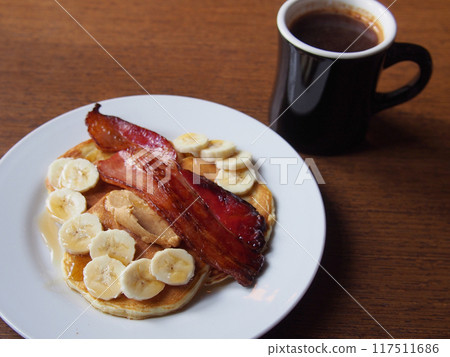 Bacon, peanut cream, banana pancakes and coffee 117511686