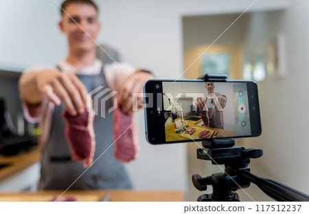 The chef is broadcasting live from workshop how to prepare a beef steaks on the electric grill The chef is broadcasting live from workshop how to prepare a beef steaks on the electric grill 117512237