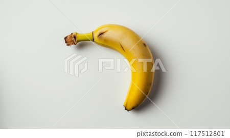 Ripe yellow banana with slight bruising isolated on a white background in a minimalistic setting Ripe yellow banana with slight bruising isolated on a white background in a minimalistic setting 117512801