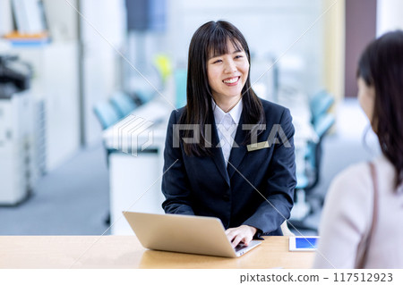 在接待處與一名婦女穿著西裝諮詢的形象 117512923