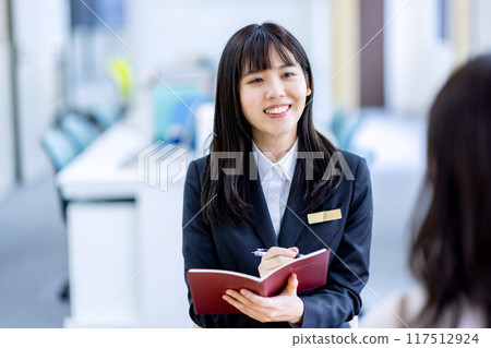 Image of consulting a woman in a suit at the reception 117512924