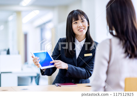 Image of consulting a woman in a suit at the reception 117512925