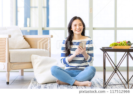 Young woman looking at a smartphone 117512966