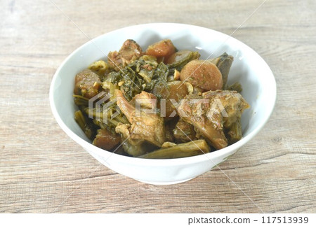 boiled mixed vegetable with braised pork bone in black soybean soup in bowl on table boiled mixed vegetable with braised pork bone in black soybean soup in bowl on table 117513939