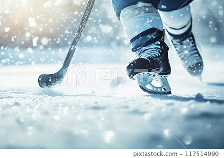 Hockey player skating and controlling the puck on a snowy rink 117514990