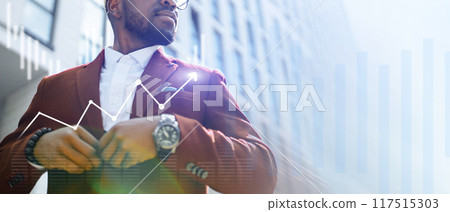 A man in a suit is wearing a watch and looking at a graph A man in a suit is wearing a watch and looking at a graph 117515303