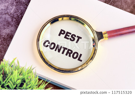 Pest control phrase written through a magnifying glass in a business record book 117515320