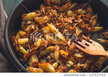 Fried chanterelles with mushrooms, in a clay pan, close-up, top view, selective focus, Fried chanterelles with mushrooms, in a clay pan, close-up, top view, selective focus, 117515753