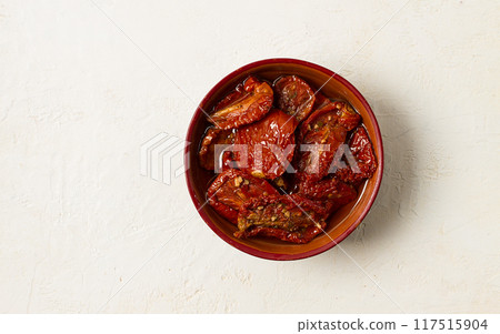 dried tomatoes, in a bowl, top view, on a white background, 117515904