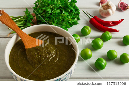 Tkemali sauce, traditional Georgian cuisine, green cherry plum, on a white wooden table, close-up, rustic, food background, no people, selective focus, 117515906