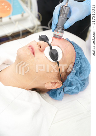 Light infrared therapy. Cosmetology head procedure. Beauty woman face. Cosmetic 117516312