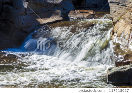 A tranquil stream flowing through the countryside in the Snowy Mountains 117518027