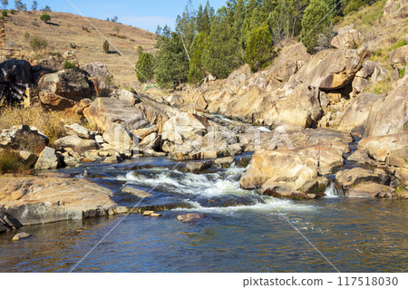 A tranquil stream flowing through the countryside in the Snowy Mountains 117518030