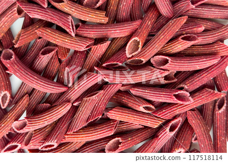 Penne red beet pasta on a kitchen plate. Macro shot. Italian vegetable gluten free food Penne red beet pasta on a kitchen plate. Macro shot. Italian vegetable gluten free food 117518114