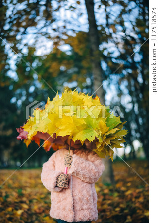 Autumn portrait of little girl with umbrella covered with yellow maple leaves Autumn portrait of little girl with umbrella covered with yellow maple leaves 117518573