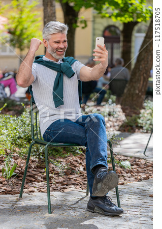 Happy man use mobile smartphone celebrating win good message news lottery jackpot casino app victory 117518705