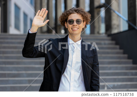 Businessman smiling friendly at camera, waving hands gesturing hi, greeting or goodbye welcoming 117518738