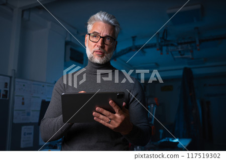 Automation engineer, technician holding remote controller of robotic arm. Concept of modern technology in industries, automated processes, robotics. 117519302