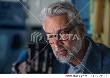 Robotics engineer adjusting, calibring robotic prosthetic hand. Concept of modern technology in medicine. Robotic prosthetics, biomechatronics and neuroscience. 117519314