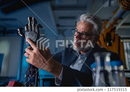 Robotics engineer adjusting, calibring robotic prosthetic hand. Concept of modern technology in medicine. Robotic prosthetics, biomechatronics and neuroscience. 117519315