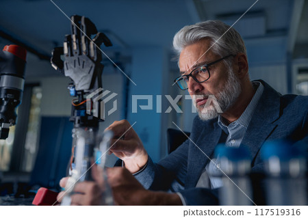 Robotics engineer adjusting, calibring robotic prosthetic hand. Concept of modern technology in medicine. Robotic prosthetics, biomechatronics and neuroscience. 117519316