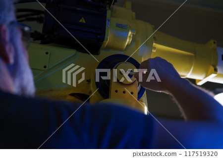 Automation engineer checking, servicing robotic arm. Concept of modern technology in industries, automated processes, robotics. 117519320