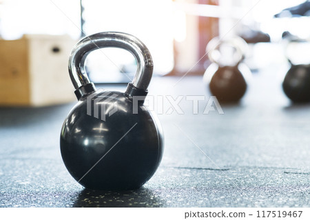 Kettlebells on floor in gym. Gym equipment for strength training. Kettlebells on floor in gym. Gym equipment for strength training. 117519467