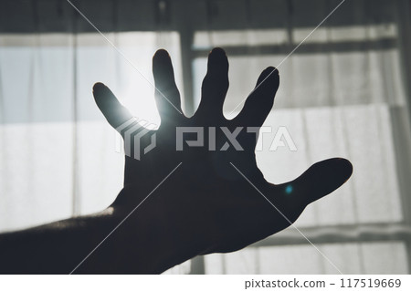 Person holding hand over window glass 117519669