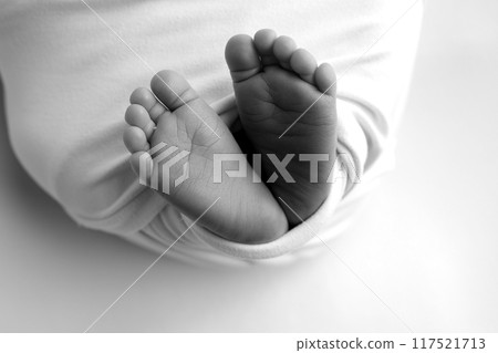 Foot of a newborn. Close up feet, toes, heels, feet of a newborn baby. Studio monochrome, vintage style, black and white macro photography. Foot of a newborn. Close up feet, toes, heels, feet of a newborn baby. Studio monochrome, vintage style, black and white macro photography. 117521713