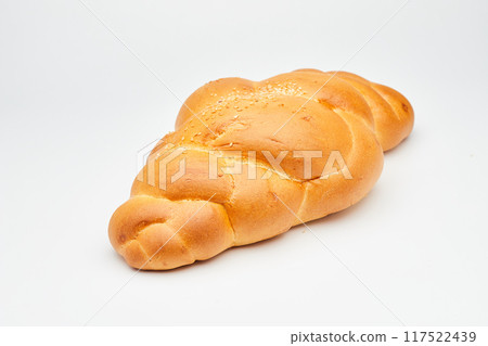 Soft golden braided bread with sesame seeds on a white background, perfect for food stock photos Soft golden braided bread with sesame seeds on a white background, perfect for food stock photos 117522439