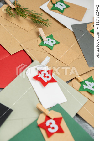 Number on craft envelopes notes with tasks before Christmas holidays. Female making kraft paper for handmade advent calendar Made with your own hands step by step DIY Number on craft envelopes notes with tasks before Christmas holidays. Female making kraft paper for handmade advent calendar Made with your own hands step by step DIY 117522442